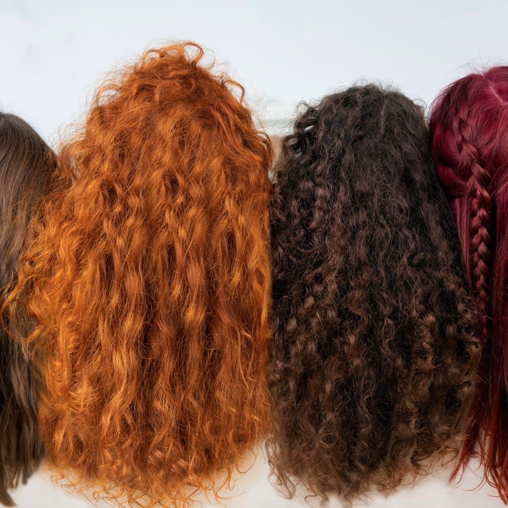Shot of diverse group of models with burgundy, copper red, black, and blonde hair.